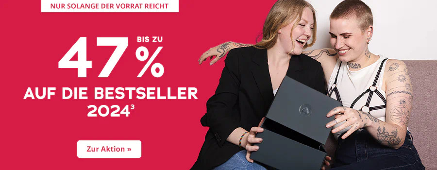 Werbemittel mit einer Rabattaktion von bis zu 47 % auf die Bestseller 2024. Auf der einen Seite ist der Hintergrund rot gestaltet mit der weissen Aufschrift: “Bis zu 47% auf die Bestseller 2024”. Oben ist ein weiss hinterlegtes Verknappungselement mit der Aufschrift: “Nur solange der Vorrat reicht”. Auf der anderen Seite ist ein Bild. Im Bild sitzen zwei lachende Personen auf einem Sofa. Eine Person trägt einen schwarzen Blazer, die andere ein weisses Top mit schwarzem, detailreichem Trägerdesign und Tattoos auf den Armen. Beide halten gemeinsam eine geöffnete schwarze Box und freuen sich. Am unteren Rand befindet sich ein Call-to-Action-Button mit der Aufschrift “Zur Aktion »”.